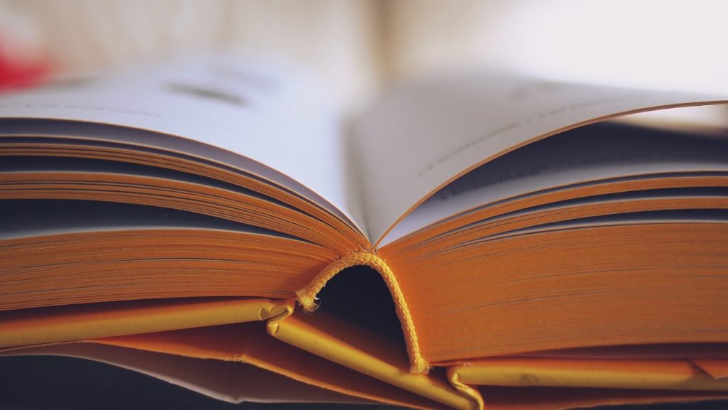 pexels-photo-261821 Detailed close-up of an open book with yellow pages, emphasizing learning and knowledge.